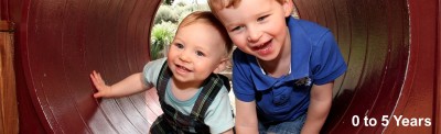Long banner showing image of 2 small children crawling through a concrete tube.