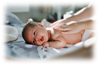 Image shows a baby lay on their tummy, receiving baby massage.